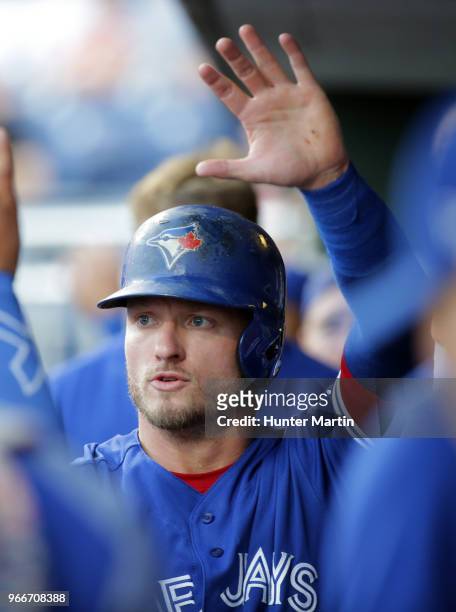 Josh Donaldson of the Toronto Blue Jays high-fives teammates in the dugout during a game against the Philadelphia Phillies at Citizens Bank Park on...