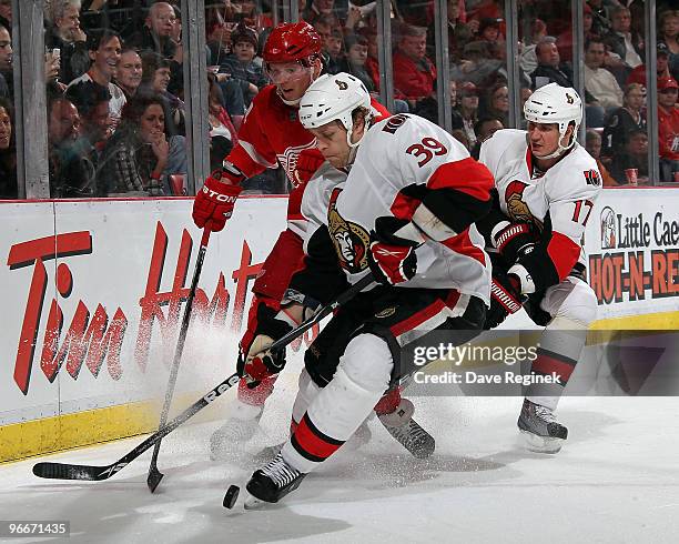 Matt Carkner of the Ottawa Senators and teammate Filip Kuba try to keep the loose puck away from Dan Cleary of the Detroit Red Wings during an NHL...