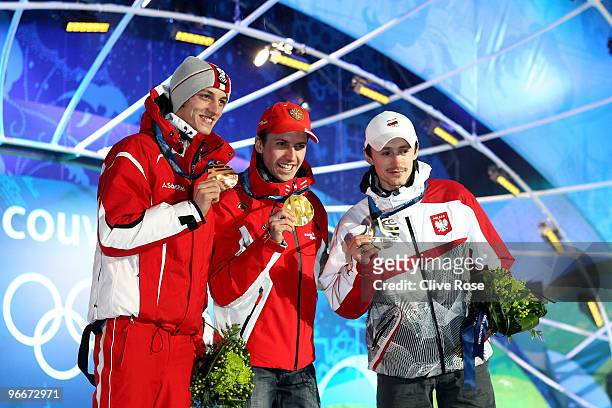 Simon Ammann of Switzerland celebrates with his gold medal and Adam Malysz of Poland and Gregor Schlierenzauer of Austria during the Medal Ceremony...