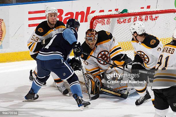 Goaltender Tuukka Rask of the Boston Bruins stops a point blank shot by Gregory Campbell of the Florida Panthers while getting help defending by...