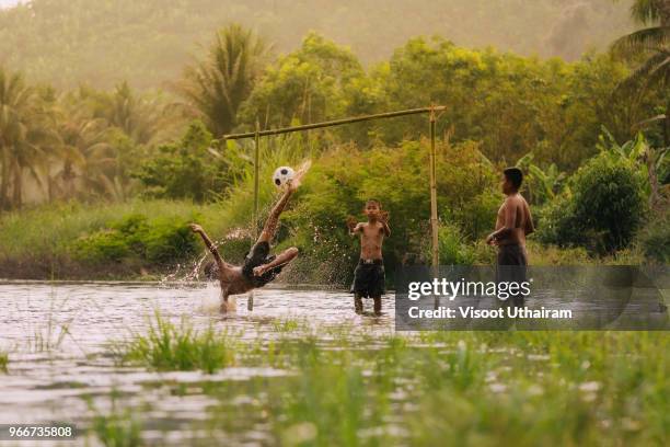 children playing football in the river. - kids at river photos et images de collection