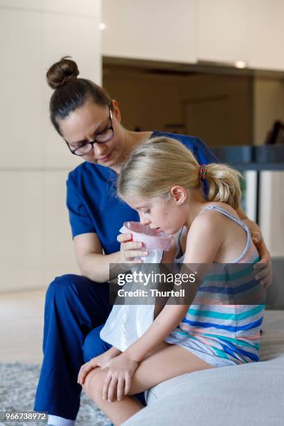 home call nurse using sick bag with child at home - sick bag stock pictures, royalty-free photos & images