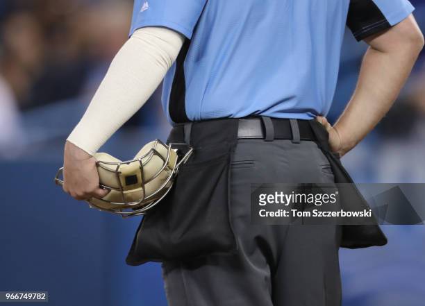 Home plate umpire Quinn Wolcott holds his mask by his side during the Seattle Mariners MLB game against the Toronto Blue Jays at Rogers Centre on May...