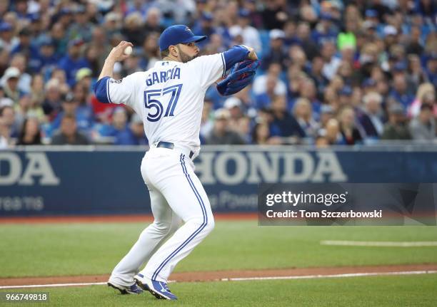 Jaime Garcia of the Toronto Blue Jays fields a soft infield single by Jean Segura of the Seattle Mariners but cannot throw him out in time in the...