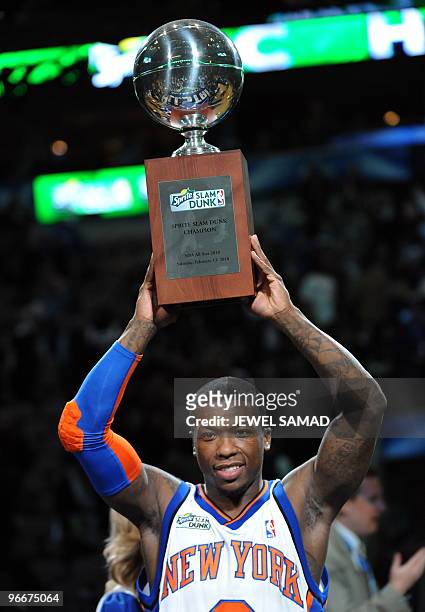 Nate Robinson of the New York Knicks celebrates his third win with the Champions Trophy after the Sprite Slam Dunk Contest on All-Star Saturday...