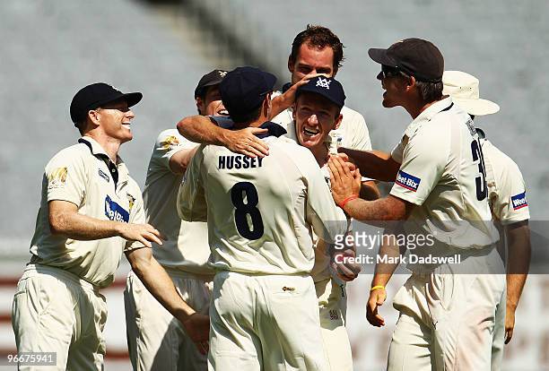 Damien Wright of the Bushrangers is congratulated by teammates after catching Simon Katich of the Blues off the bowling of John Hastings during day...