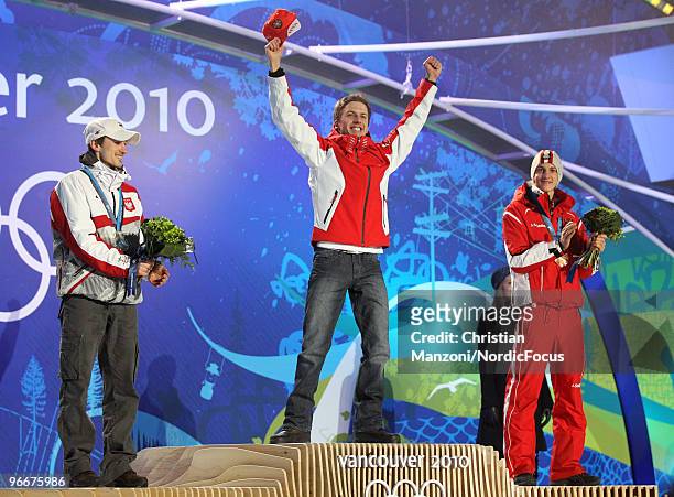 Swiss Simon Ammann celebrates on the podium as Poland's Adam Malysz and Austrian Gregor Schlierenzauer look on during the medal ceremony for the Ski...