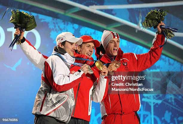 Swiss Simon Ammann , Poland's Adam Malysz and Austrian Gregor Schlierenzauer display their medals on the podium during the medal ceremony for the Ski...