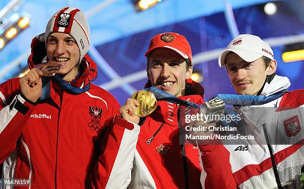 Swiss Simon Ammann , Poland's Adam Malysz and Austrian Gregor Schlierenzauer display their medals on the podium during the medal ceremony for the Ski...