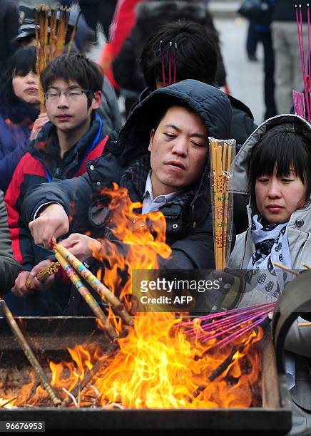People burn incense to celebrate the first day of the Chinese New Year at Dongyue Miao, the Taoist Temple of the Eastern Peak, in Beijing on February...