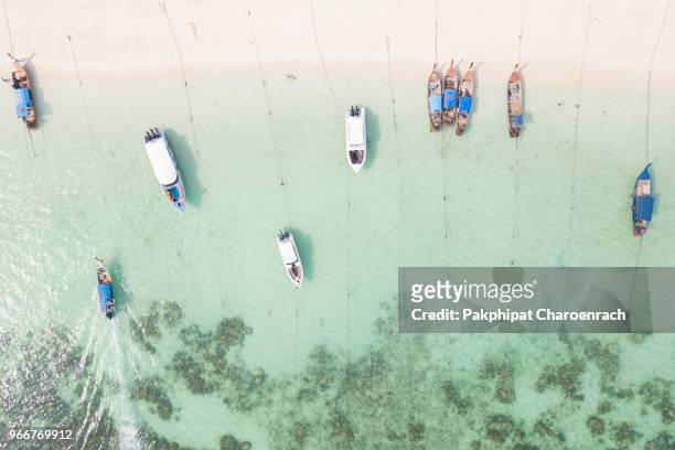 aerial view of thai traditional longtail boats on tropical white sand at sunrise beach, lipe island, thailand. - mettre knock out photos et images de collection