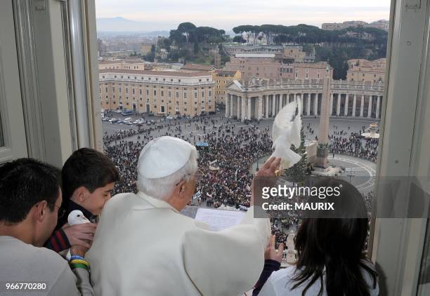 Pope Benedict XVI, with youths from Catholic groups at his side, frees a white dove as a symbol of peace at the end of the Angelus prayer he...