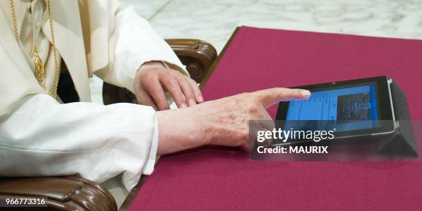 Pope Benedict XVI clicks on a tablet to send his first twitter message at the end of his weekly general audience on December 12, 2012 at the Paul VI...