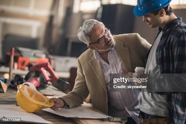 quality control inspector talking to young manual worker in a workshop. - manual control stock pictures, royalty-free photos & images