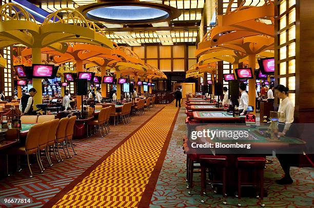 Casino workers stand ready to receive the first gamblers at the soft opening of Genting Singapore Plc's Resorts World Sentosa casino in Singapore, on...