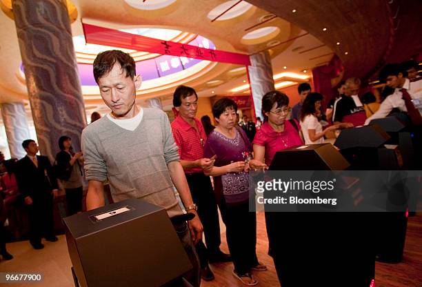 The first gamblers enter the casino at Genting Singapore Plc's Resorts World Sentosa on its first day of operation, in Singapore, on Sunday, Feb. 14,...
