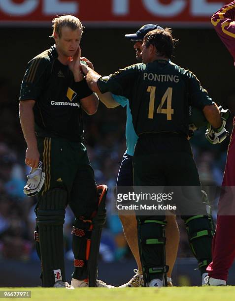 Cameron White of Australia is assessed by team physio Alex Kountouris and Ricky Ponting after being struck on the head by Kieron Pollard of the West...