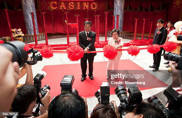 Lim Kok Thay, chairman and chief executive officer of Genting Bhd., left, cuts the ribbon with his mother, Lee Kim Hua, during the ceremony marking...