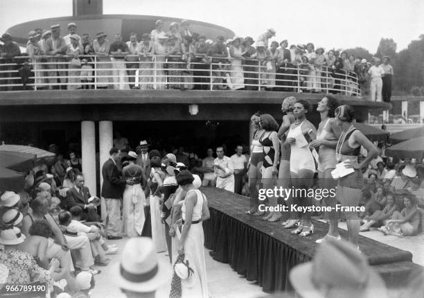 Jeunes femmes sur le podium présentent leur maillot de bain durant le concours, à Aix-les-Bains, France le 14 août 1933.