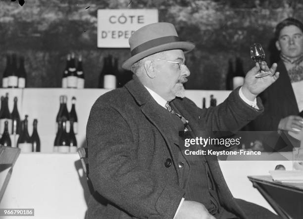 Un homme déguste le vin dans les celliers de la maison Pol Roger, à Epernay, France le 23 mars 1934.