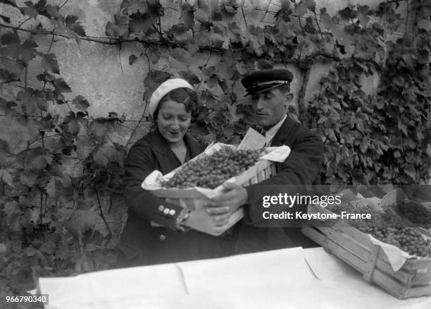 Femme portant une caisse de grappes de raison lors de la traditionelle vente aux enchères du raisin chasselas de la Treille du Roy à Fontenaibleau,...