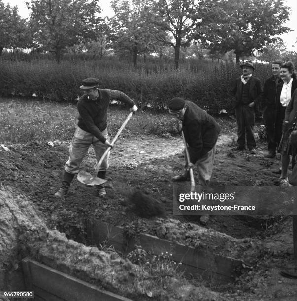 Deux hommes creusent le trou qui recevra le corps de Pierre Laval dans la fosse commune du cimetière de Thiais, France le 15 octobre 1945.