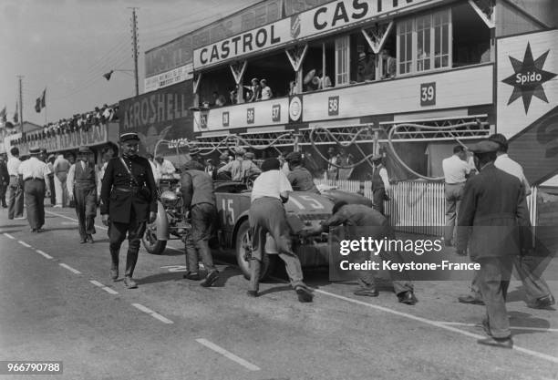 Juste avant le départ de la course, on pousse une voiture sur la ligne de départ, Le Mans, France le 18 juin 1934.