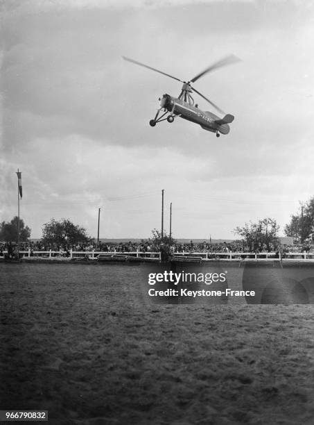 Pendant la fête du 'Triomphe de Saint-Cyr', un autogire survole l'école militaire, à Saint-Cyr-L'Ecole, France le 18 juillet 1935.