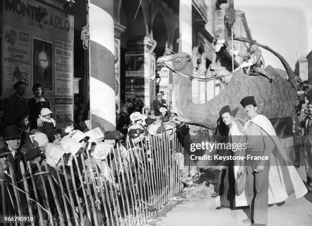 Défilé du carnaval, un chameau portant un singe amusen les enfants déguisés, à Nice, France le 25 février 1935.