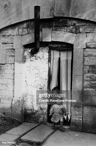 Des enfants jouent sur le perron d'une cellule du Fort de Villiers, transformé quatre ans auparavant par l'Abbé Pierre en logements de fortune pour...