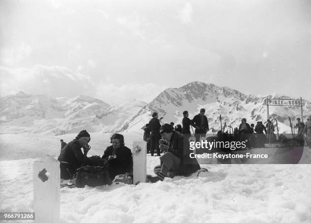 Les amateurs de ski venus assister aux championnats, prennent leur déjeuner dans la neige, à Luchon-Superbagnères, France le 27 février 1934.