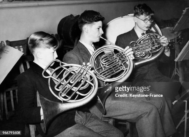 Trois adolescents jouent du cor anglais lors de leçons à l'école de musique pendant les vacances de Pâques le 16 avril 1958 à Londres, Royaume-Uni.