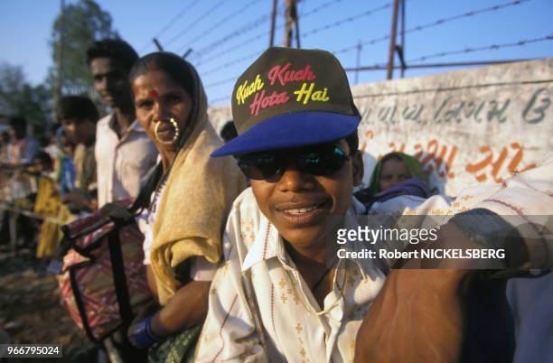 Adolescent avec une casquette portant le titre d'un film de Bollywood dans la file d'attente à la station d'autobus le 28 février 1999 à Ahwa en Inde.
