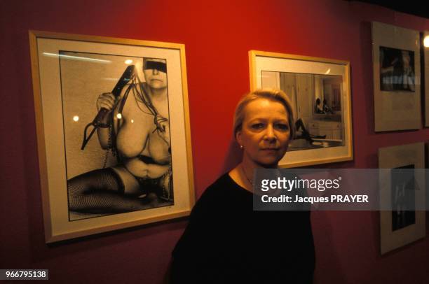 Portrait de Claude Alexandre, photographe sado-masochiste, devant ses oeuvres au Salon de l'Erotisme le 24 mars 1985 à Paris, France.