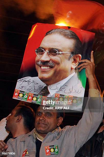 Supporter carries a portrait of Pakistan�s President Asif Ali Zardari during a pro-Zardari rally in Lahore early on February 14, 2010. Pakistan faced...