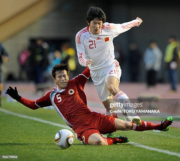 Chinese midfielder Yu Hai jumps to keep the ball over Hong Kong defender Lee Wai Lun during their match of the East Asian football championship in...