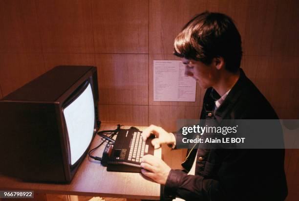 Espace informatique, travail sur ordinateur à bord d'un train-forum 'Vive l'Ecole', le 22 avril 1985 en gare de Nantes, France.