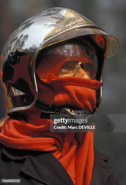 Portrait d'un pompier portant un casque lors d'un incendie le 25 août 1990 dans le Var, France.