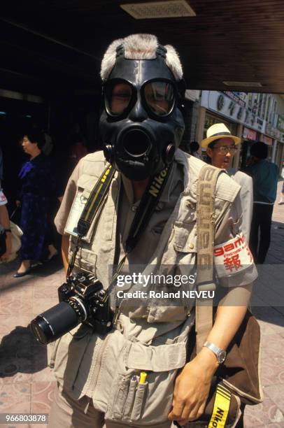 Photographe de presse portant un masque à gaz lors du soulèvement de Gwangju le 18 mai 1986, Corée du Sud.