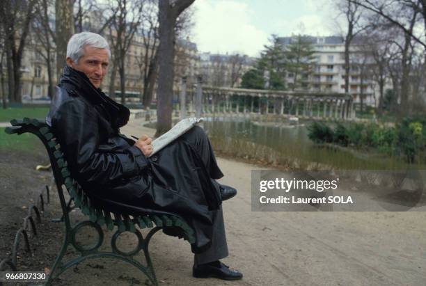 Le chanteur Marcel Amont sur un banc dans un parc public le 28 mars 1986 à Paris, France.