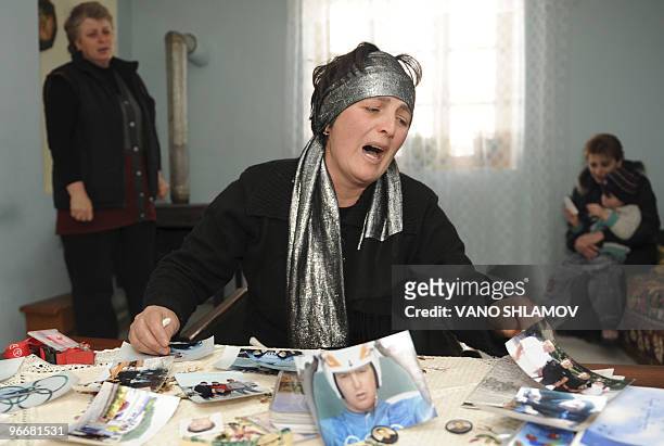 Dodo Kharazishvili mother of late Georgian olympic luger Nodar Kumaritashvili, cries while looking at photos of her son at their home 180km from...