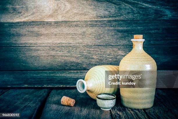 still life of sake bottles with light on wood background. - sake stock-fotos und bilder