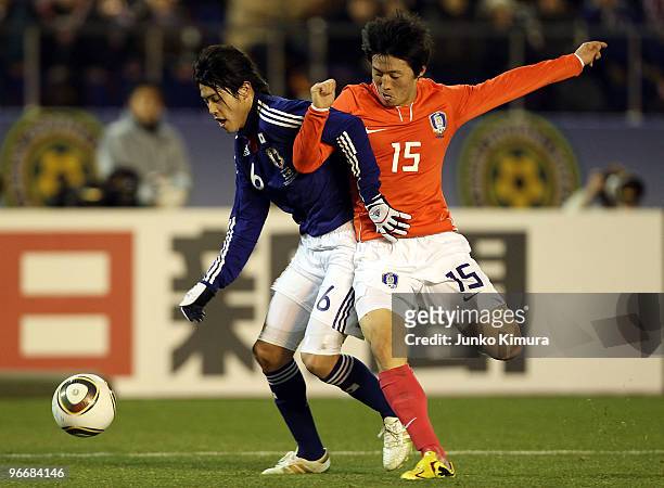 Atsuto Uchida of Japan and Bo Kyung Kim of South Korea compete for the ball during the East Asian Football Championship 2010 match between Japan and...