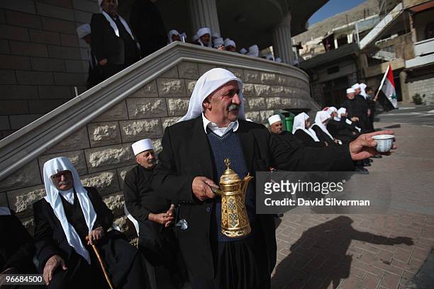 Druze man serves traditional bitter coffee to the elders of his community as they gather for a rally in support the Damascus regime on February 14,...