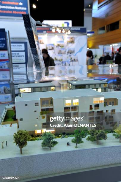 Maquette d'un projet immobilier et visiteurs sur le stand d'un promoteur lors d'un salon immobilier, le 18 Mars 2016 à Nantes, Ouest de la France.