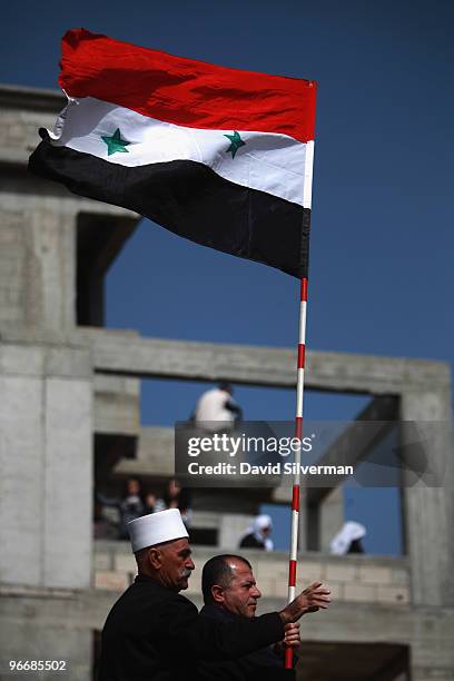 Druze man waves a Syrian flag as his community rallies close to the Syrian border in support the Damascus regime on February 14, 2010 in Majdal Shams...