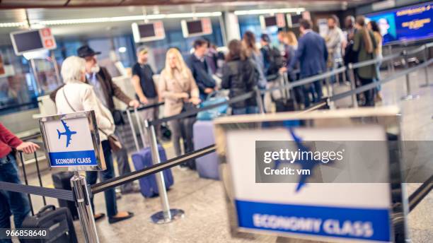 airline passengers waiting in line - lining up imagens e fotografias de stock