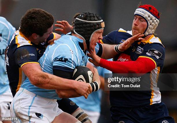 Ben Woods of Leicester Tigers is challenged by Calum Clark and Andy Titterrell of Leeds Carnegie during the Guinness Premiership match between Leeds...