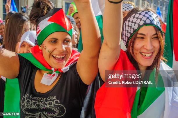 Manifestantes portant le drapeau palestinien lors d'un rassemblement devant l'Hotel de ville en signe de solidarité avec le peuple palestinien...