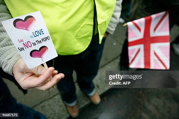 Protester poses with a small placard during a demonstration against perceived intervention by the Vatican in Italian, European and world-wide...